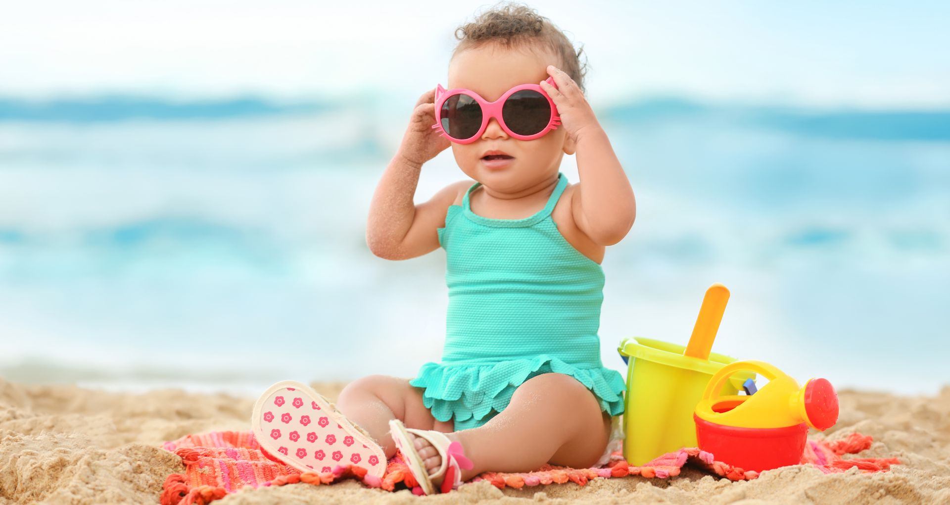 Baby wearing sunglasses at the beach